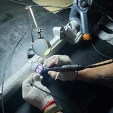 gloved hands fixing manufactured part